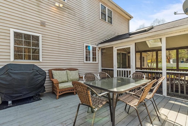 wooden deck featuring area for grilling, outdoor dining space, a sunroom, and an outdoor hangout area