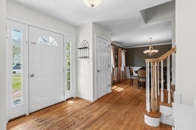 foyer with light wood-type flooring, baseboards, and a chandelier