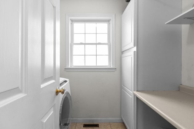 laundry area with visible vents, light tile patterned flooring, baseboards, washer / clothes dryer, and cabinet space