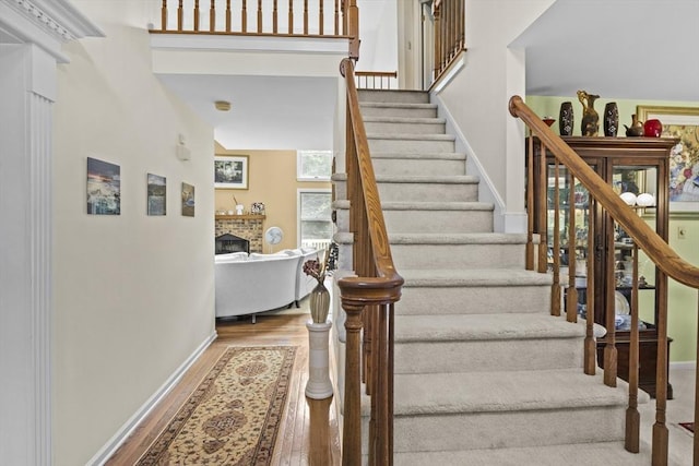 63 Forge Rd, Sharon, MA 02067 - stairs with wood finished floors, baseboards, and a brick fireplace