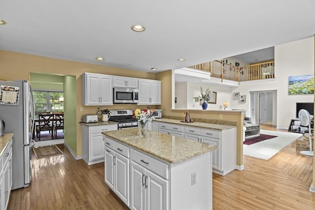63 Forge Rd, Sharon, MA 02067 - kitchen featuring appliances with stainless steel finishes, a peninsula, light wood-style flooring, white cabinets, and recessed lighting