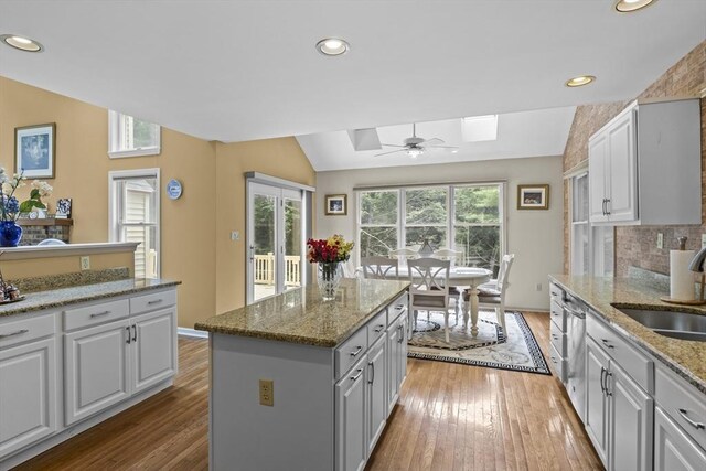 63 Forge Rd, Sharon, MA 02067 - kitchen featuring a sink, vaulted ceiling, hardwood / wood-style floors, a skylight, and a center island