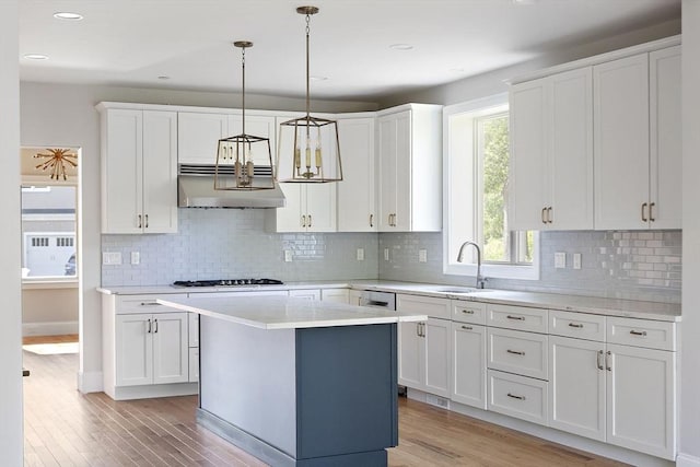 16 Pine Hill Rd Unit 16, Wenham, MA 01984 - kitchen featuring under cabinet range hood, white gas stovetop, light wood-style floors, white cabinets, and light countertops
