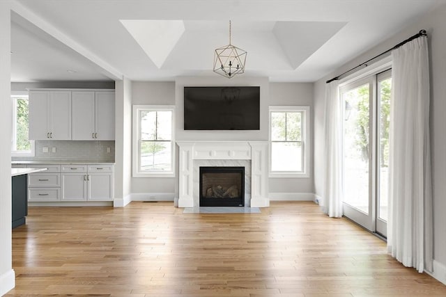 16 Pine Hill Rd Unit 16, Wenham, MA 01984 - unfurnished living room featuring light wood-style flooring, a premium fireplace, a chandelier, and vaulted ceiling