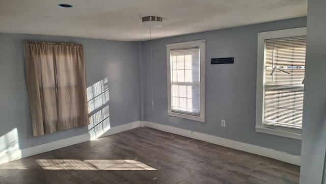 empty room with dark hardwood / wood-style flooring