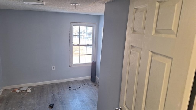 unfurnished room featuring hardwood / wood-style floors and a textured ceiling