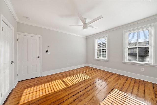 unfurnished room featuring ceiling fan, baseboards, light wood-type flooring, and ornamental molding