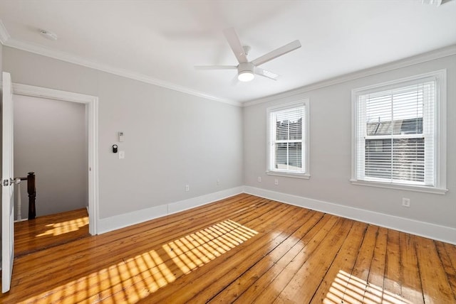 spare room with crown molding, light wood-style floors, and baseboards