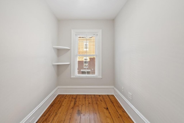 empty room with baseboards and hardwood / wood-style flooring