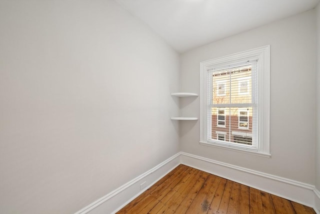 empty room with baseboards and wood-type flooring