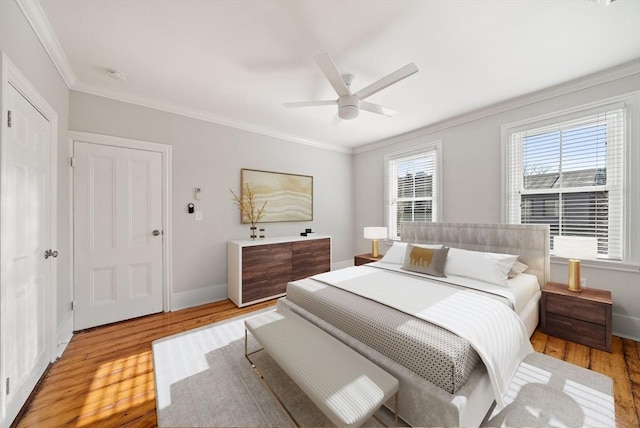 bedroom featuring crown molding, light wood-style flooring, a ceiling fan, and baseboards