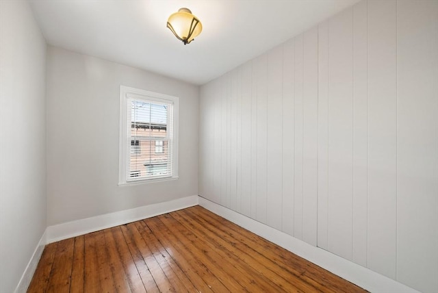 empty room featuring baseboards and wood-type flooring