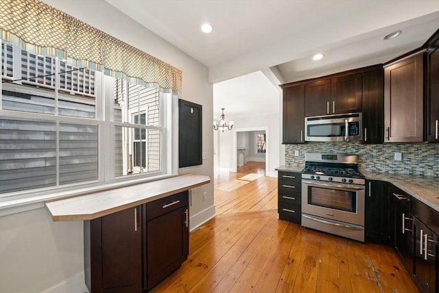 kitchen featuring stainless steel appliances, tasteful backsplash, dark brown cabinets, and hardwood / wood-style floors