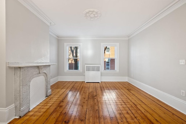 interior space with baseboards, radiator, wood-type flooring, and crown molding