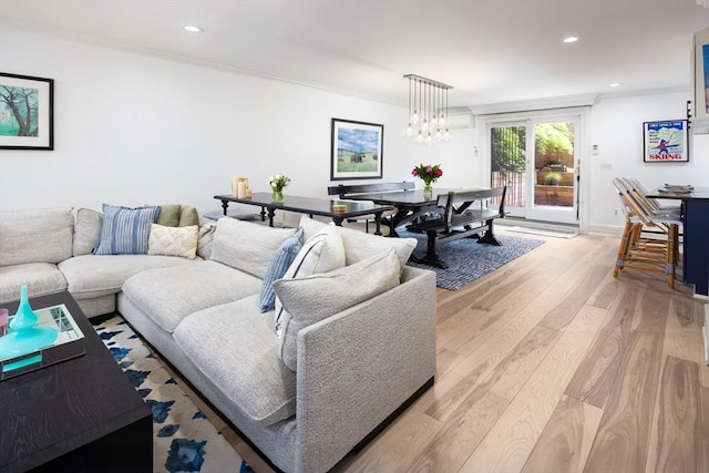 living area with ornamental molding, light wood-type flooring, recessed lighting, baseboards, and a chandelier