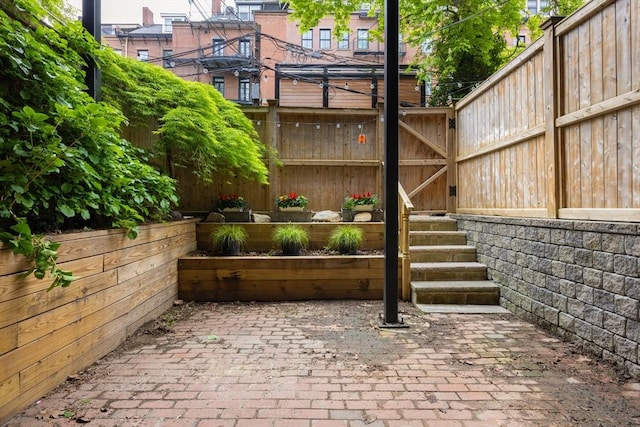 view of patio with fence and a garden