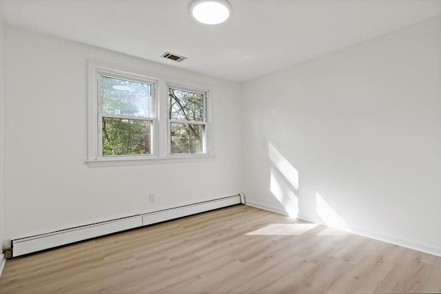 unfurnished room featuring a baseboard radiator, baseboards, light wood-type flooring, and visible vents