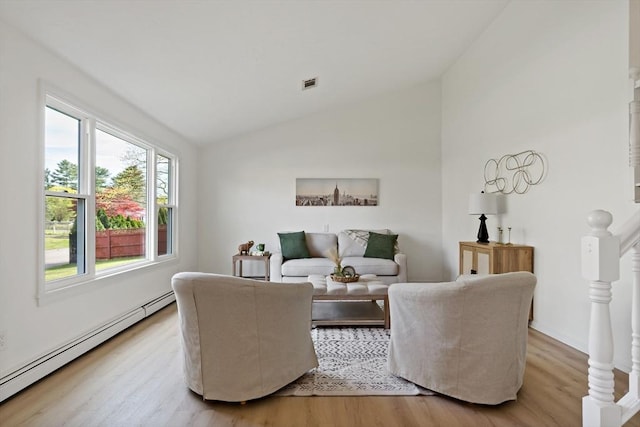 living room featuring lofted ceiling, wood finished floors, visible vents, and a baseboard heating unit
