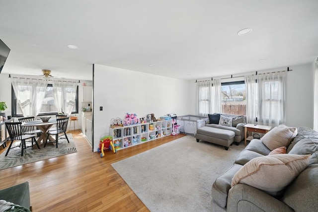 living area with recessed lighting, light wood-type flooring, a healthy amount of sunlight, and a ceiling fan