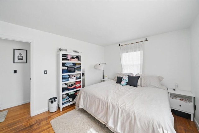 bedroom featuring baseboards and wood finished floors