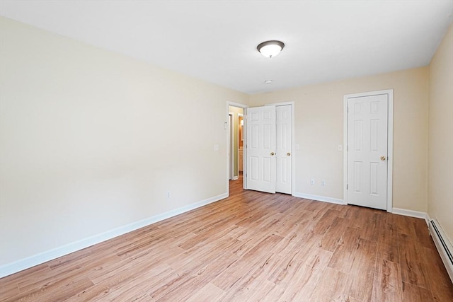 50 Maggie Ln, Southbridge, MA 01550 - unfurnished bedroom featuring a baseboard heating unit, light wood finished floors, baseboards, and a closet