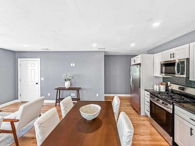 dining room with light wood finished floors, recessed lighting, and baseboards