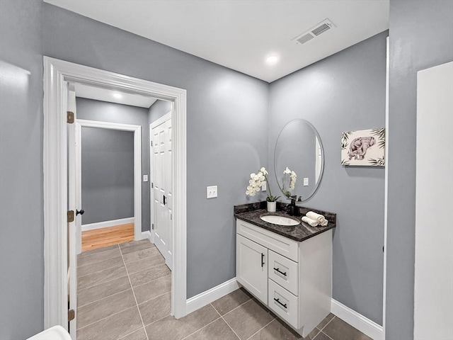 bathroom with tile patterned flooring, vanity, and baseboards
