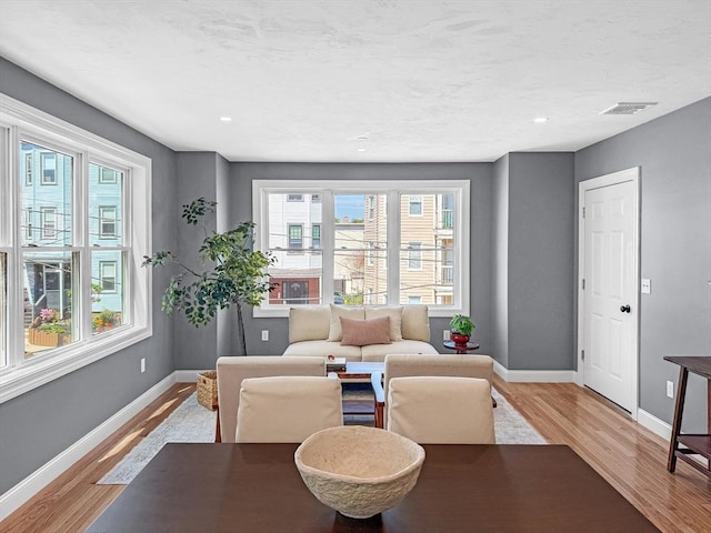 living area featuring light wood-style floors, baseboards, and recessed lighting