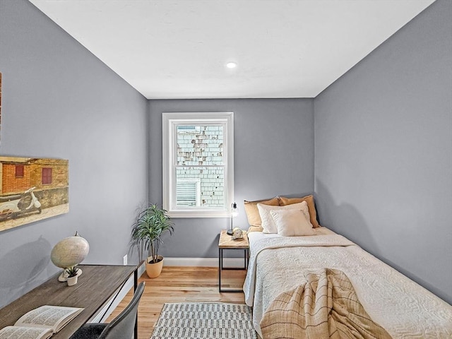 bedroom with wood finished floors, baseboards, and recessed lighting