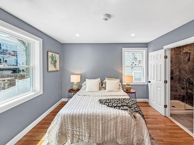 bedroom with multiple windows, wood finished floors, baseboards, and recessed lighting