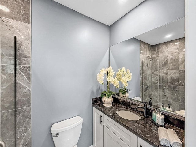 bathroom with a stall shower, toilet, and vanity