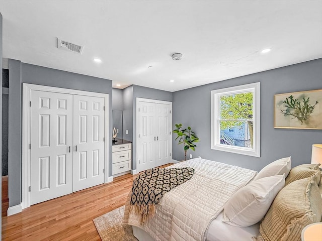 bedroom with multiple closets, light wood-style floors, recessed lighting, and baseboards