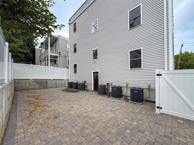 21 Thornton St Unit 4, Revere, MA 02151 - view of home's exterior featuring central air condition unit, a fenced backyard, a gate, and a patio area