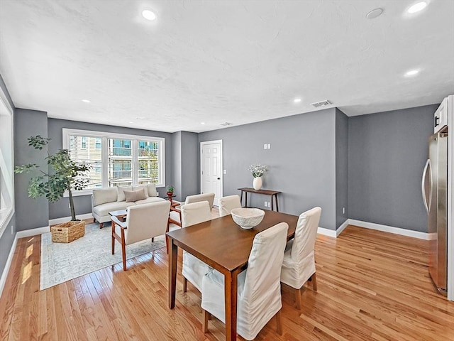 dining area with baseboards, light wood-style flooring, and recessed lighting