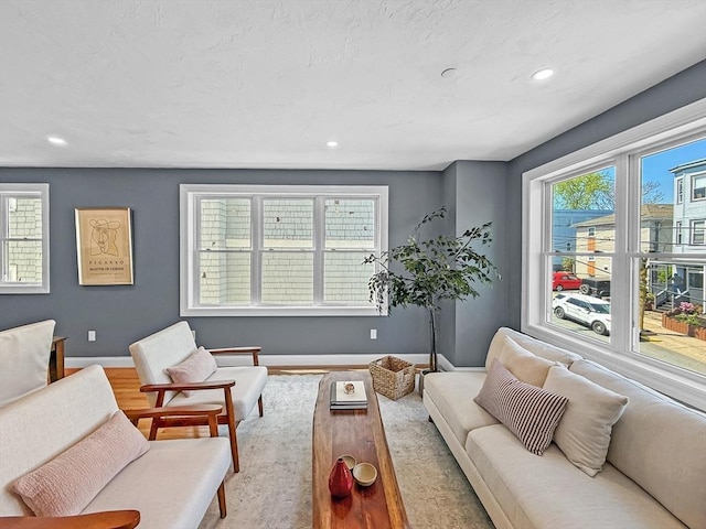 living area featuring baseboards, recessed lighting, and wood finished floors