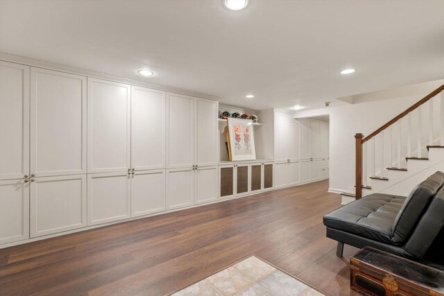 sitting room with recessed lighting, wood finished floors, and stairs