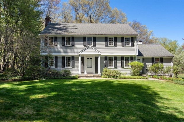 view of front facade with a front lawn and a chimney
