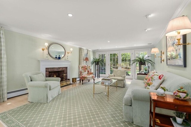 living area with crown molding, wood finished floors, a fireplace with raised hearth, a baseboard heating unit, and recessed lighting