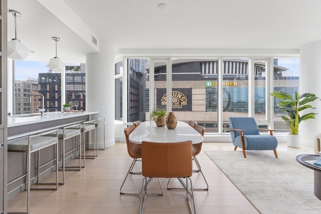 dining space with light wood-type flooring and sink