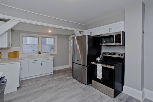 kitchen featuring white cabinets, stainless steel appliances, backsplash, and light hardwood / wood-style flooring