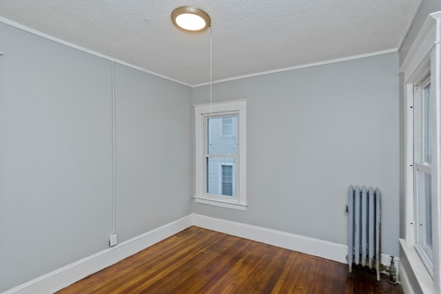 spare room with ornamental molding, radiator, a textured ceiling, and dark hardwood / wood-style floors