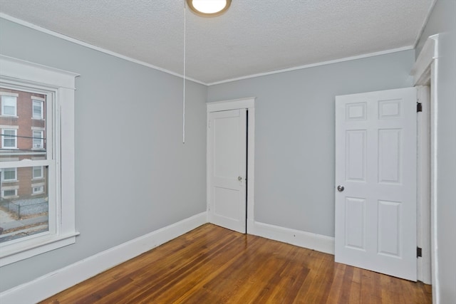 unfurnished room featuring ornamental molding, dark wood-type flooring, and a textured ceiling