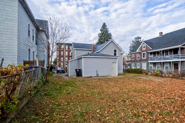 back of house with a yard and a balcony