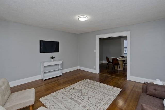 living room featuring dark hardwood / wood-style flooring and a textured ceiling