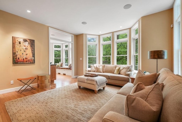 living room with light wood-style floors, baseboards, and recessed lighting