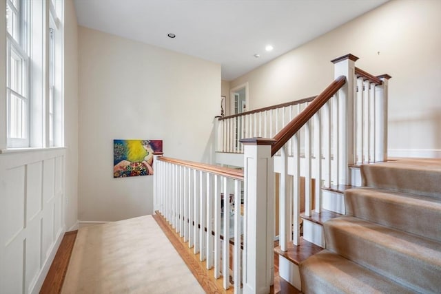 stairs featuring baseboards, wood finished floors, and recessed lighting