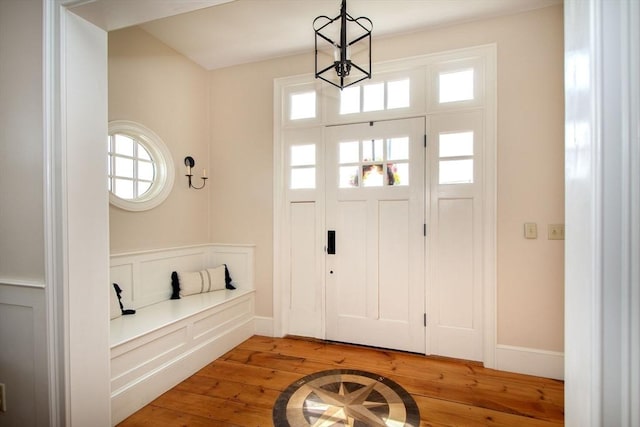 foyer with hardwood / wood-style flooring and a chandelier