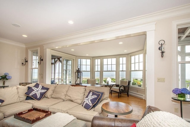 living room with ornamental molding, light hardwood / wood-style flooring, and a baseboard heating unit