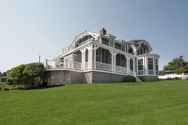 view of side of home with a sunroom and a yard