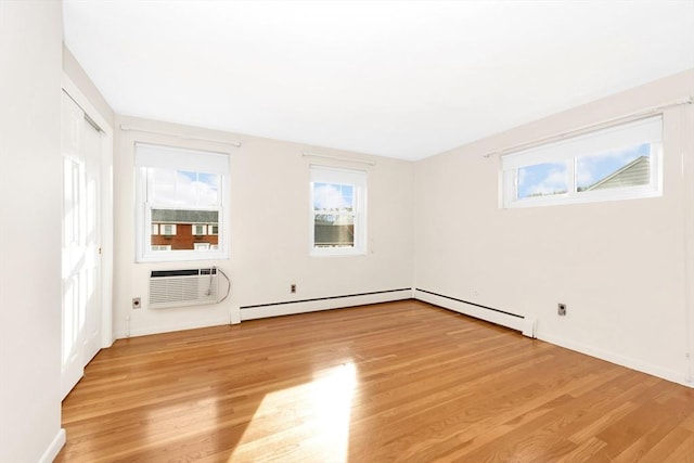 unfurnished room featuring plenty of natural light, an AC wall unit, and light hardwood / wood-style flooring